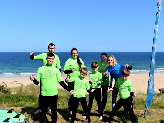 Family group surfing lesson at Gwithian Hayle beach, Cornwall.
